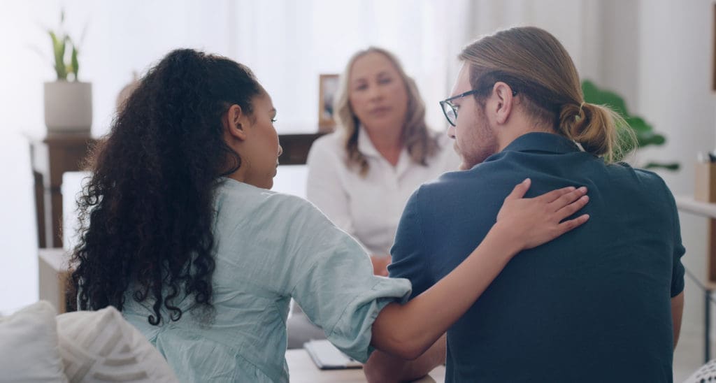 Marriage, counselling and couple in therapist office giving comfort, care and talking to partner